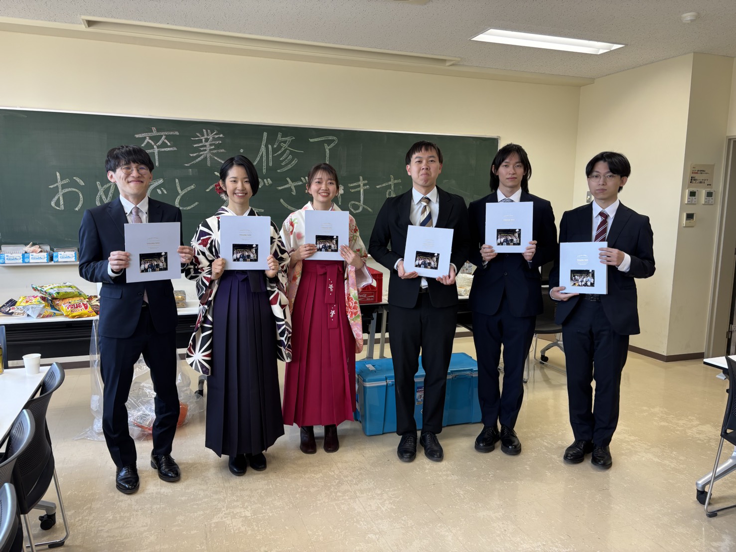 後輩から寄せ書きをもらい笑顔の卒業生の集合写真